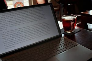 Laptop with a drink in a coffee shop.