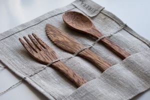 brown wooden fork, spoon, and knife on textile